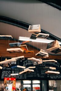 Bücher hängen von Schnüren an der Decke eines Cafés
