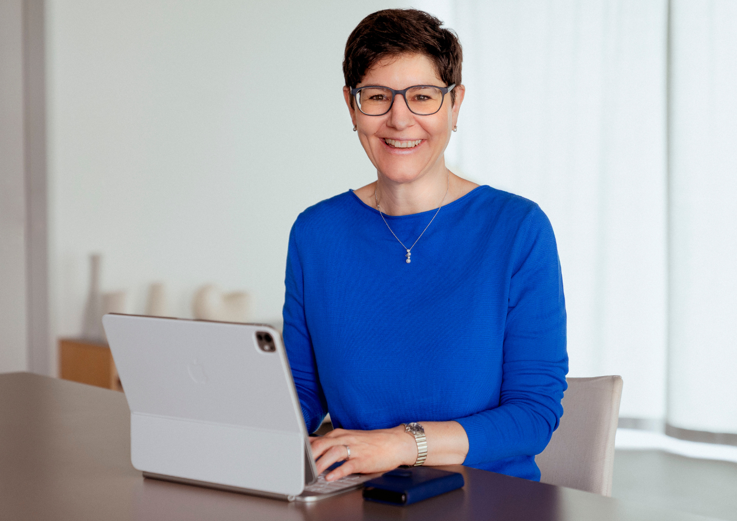 Ordnungscoach Karin Treichler sitzt an Ihrem Schreibtisch mit dem Laptop vor sich. Es ist nie zu spät neu anzufangen