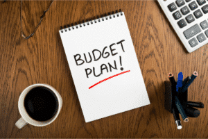 Notizheft für die Budgetplanung neben einem Taschenrechner