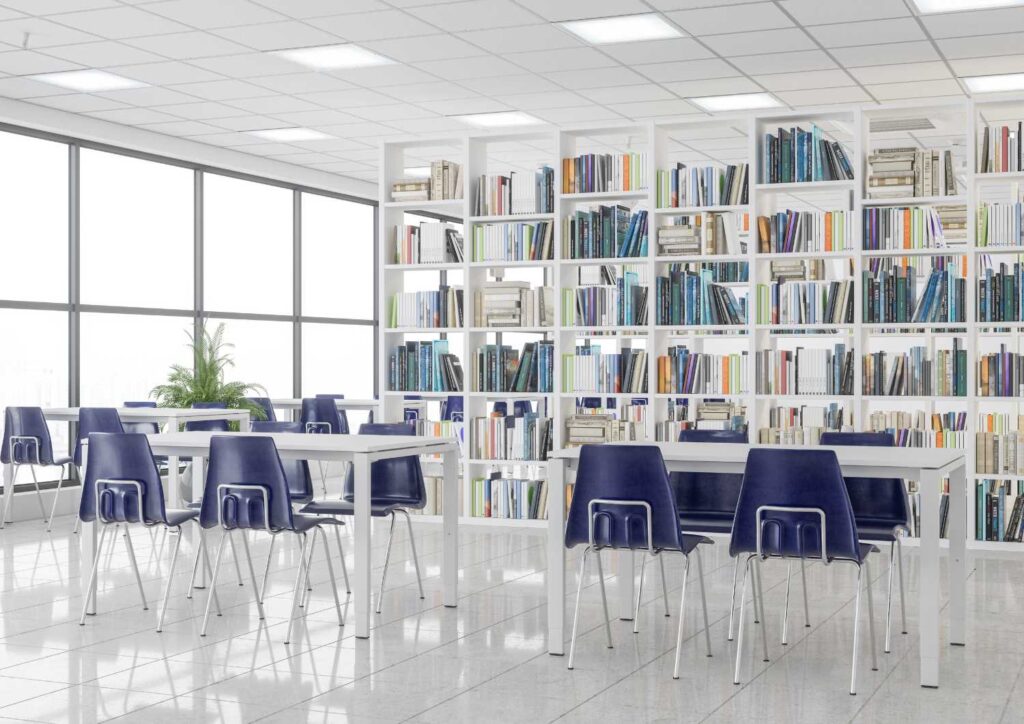 Eine Bibliothek mit einem Bücherregal und blauen Stühlen.